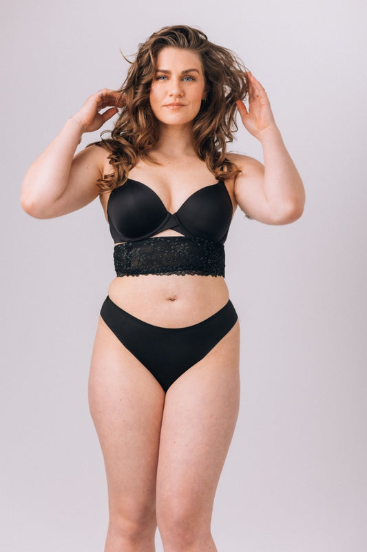 This image features the "Isabella Band," a stylish under-bust accessory designed to both enhance your outfit and discreetly hold personal items. The band is crafted in a sleek, black fabric, complementing a variety of styles.