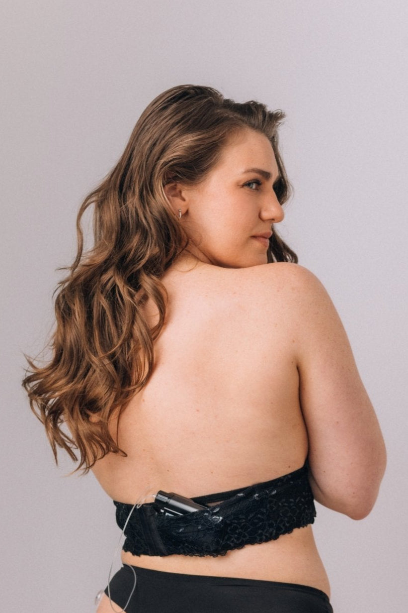 Woman wearing a black lace band with a pocket in which she stores her insulin pump